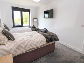 A bedroom with two beds and a television at Oak Tree Cottage in Frizington