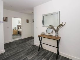 A hallway with a console table and decorative items at Oak Tree Cottage in Frizington
