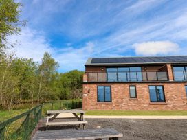 An outdoor view of a building with trees and a pathway at Oak Tree Cottage in Frizington
