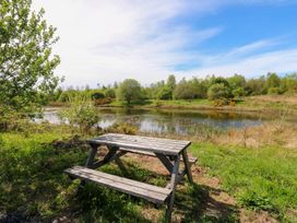 A picnic table near a pond at Oak Tree Cottage in Frizington