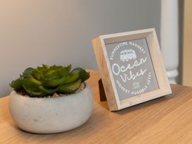 A decorative frame and a succulent plant on a wooden table at 38 Ashville Avenue Scarborough