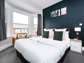 A bedroom with a bed and armchair at 38 Ashville Avenue Scarborough