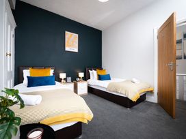A bedroom with two beds and a plant at 38 Ashville Avenue in Scarborough
