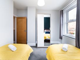 A bedroom with two beds and a mirror at 38 Ashville Avenue in Scarborough