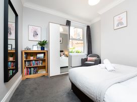 A bedroom with a bed, bookshelf, and mirror at 38 Ashville Avenue in Scarborough