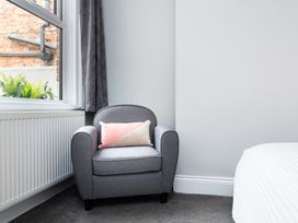 A bedroom with an armchair and window at 38 Ashville Avenue in Scarborough