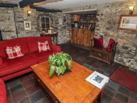 A living room with a sofa, coffee table and bar at Ty Mawr Country House, Carmarthen