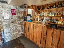 A bar area with bottles on shelves and a counter at Ty Mawr Country House in Carmarthen