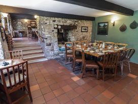 A dining room with a wooden table and chairs at Ty Mawr Country House in Carmarthen