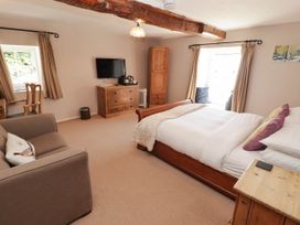 A bedroom with a bed and sofa at Ty Mawr Country House in Carmarthen