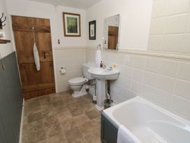 A bathroom with a bath, sink, toilet and mirror at Ty Mawr Country House in Carmarthen