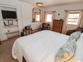 A bedroom with a bed and a television at Ty Mawr Country House in Carmarthen