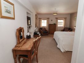 A bedroom with a bed and dressing table at Ty Mawr Country House in Carmarthen