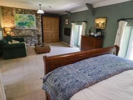 A bedroom with a bed, sofa, and dresser at Ty Mawr Country House in Carmarthen