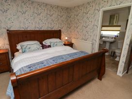 A bedroom with a wooden bed and nightstand at Ty Mawr Country House, Carmarthen