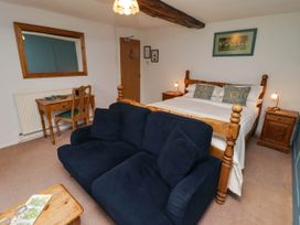 A bedroom with a bed, desk, and seating area at Ty Mawr Country House in Carmarthen