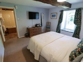 A bedroom with a bed, television, and a window at Ty Mawr Country House, Carmarthen