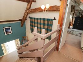 A staircase with a chair and wall decor at Ty Mawr Country House in Carmarthen