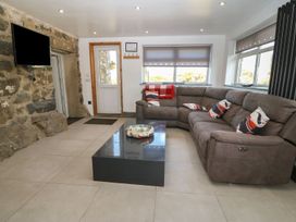 A living room with a sofa and television at Cefnbron in Caernarfon