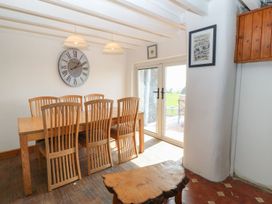 A dining room with a table and chairs at Cefnbron in Caernarfon