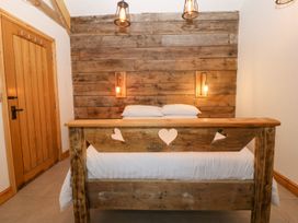 A bedroom with a wooden bed and wooden wall at Cefnbron in Caernarfon