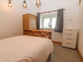 A bedroom with a bed and wardrobe at Cefnbron in Caernarfon
