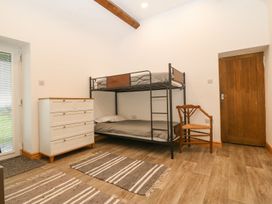 A bedroom with a bunk bed and dresser at Cefnbron Caernarfon