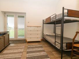 A bedroom with a bunk bed and dresser at Cefnbron in Caernarfon