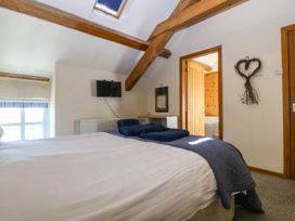 A bedroom with a bed and television at Cefnbron in Caernarfon