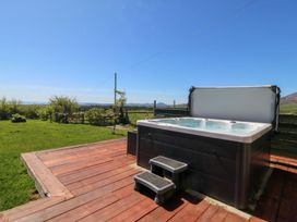 A hot tub with steps on a deck in an outdoor area at Cefnbron in Caernarfon