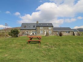 A house with a picnic table in the outdoor area at Cefnbron Caernarfon
