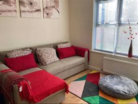 A living room with a sofa and cushions at Admirals Rest in Weymouth