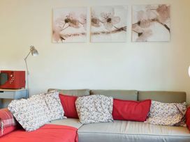 A living room with a sofa and paintings at Admirals Rest in Weymouth