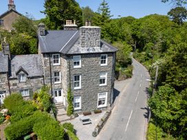 A house situated near a road surrounded by greenery at Gwynfryn House in Llanbedr