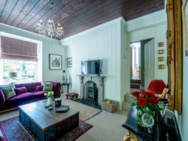 A living room with a television and sofa at Gwynfryn House in Llanbedr