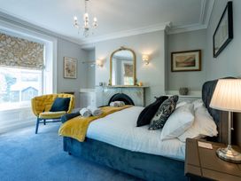 A bedroom with a bed and a sofa at Gwynfryn House in Llanbedr
