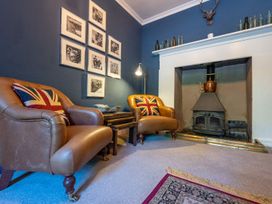A living room with armchairs and a fireplace at Gwynfryn House in Llanbedr