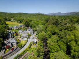 An aerial view of houses and trees in a rural area near Gwynfryn House in Llanbedr
