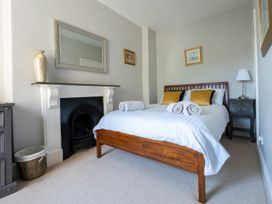 A bedroom with a bed and a mirror at Gwynfryn House Llanbedr