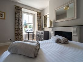 A bedroom with a bed, towels, and a chest of drawers at Gwynfryn House in Llanbedr