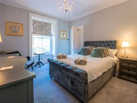 A bedroom with a bed and nightstand at Gwynfryn House in Llanbedr