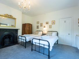 A bedroom with two beds and a fireplace at Gwynfryn House in Llanbedr