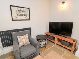 A living room with a chair and television at Canny Cottage in Belford