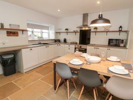 A kitchen with a table and chairs at Canny Cottage in Belford