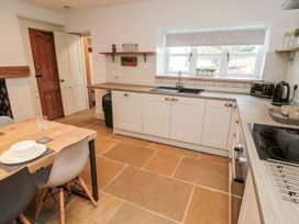 A kitchen with a table and dining chairs at Canny Cottage in Belford