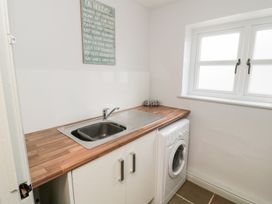 A laundry room with a sink and washing machine at Canny Cottage Belford
