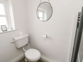A bathroom with a toilet and mirror at Canny Cottage in Belford