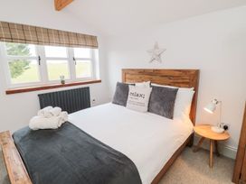 A bedroom with a bed and decorative items at Canny Cottage in Belford