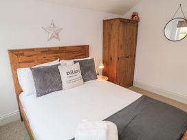 A bedroom with a bed and wardrobe at Canny Cottage in Belford