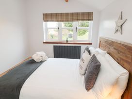 A bedroom with a bed and window at Canny Cottage in Belford